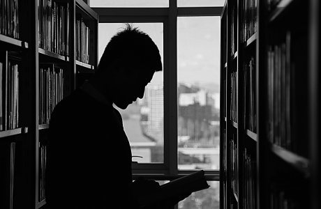 man in library reading a book