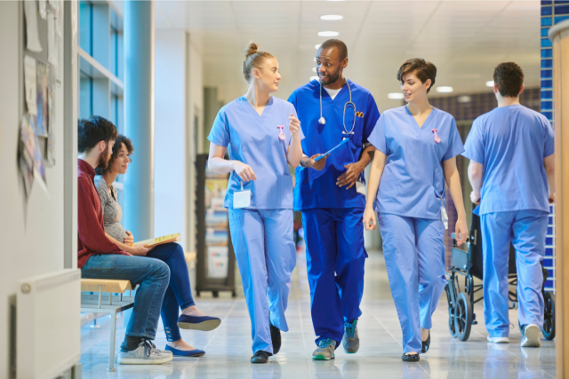 A group of doctors and nurses discussing something while walking