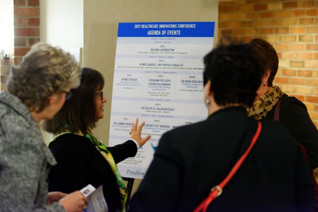 people looking at the schedule for the Pandion Healthcare Innovations Conference in 2017